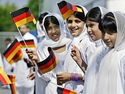Young immigrant students waiving German flag.